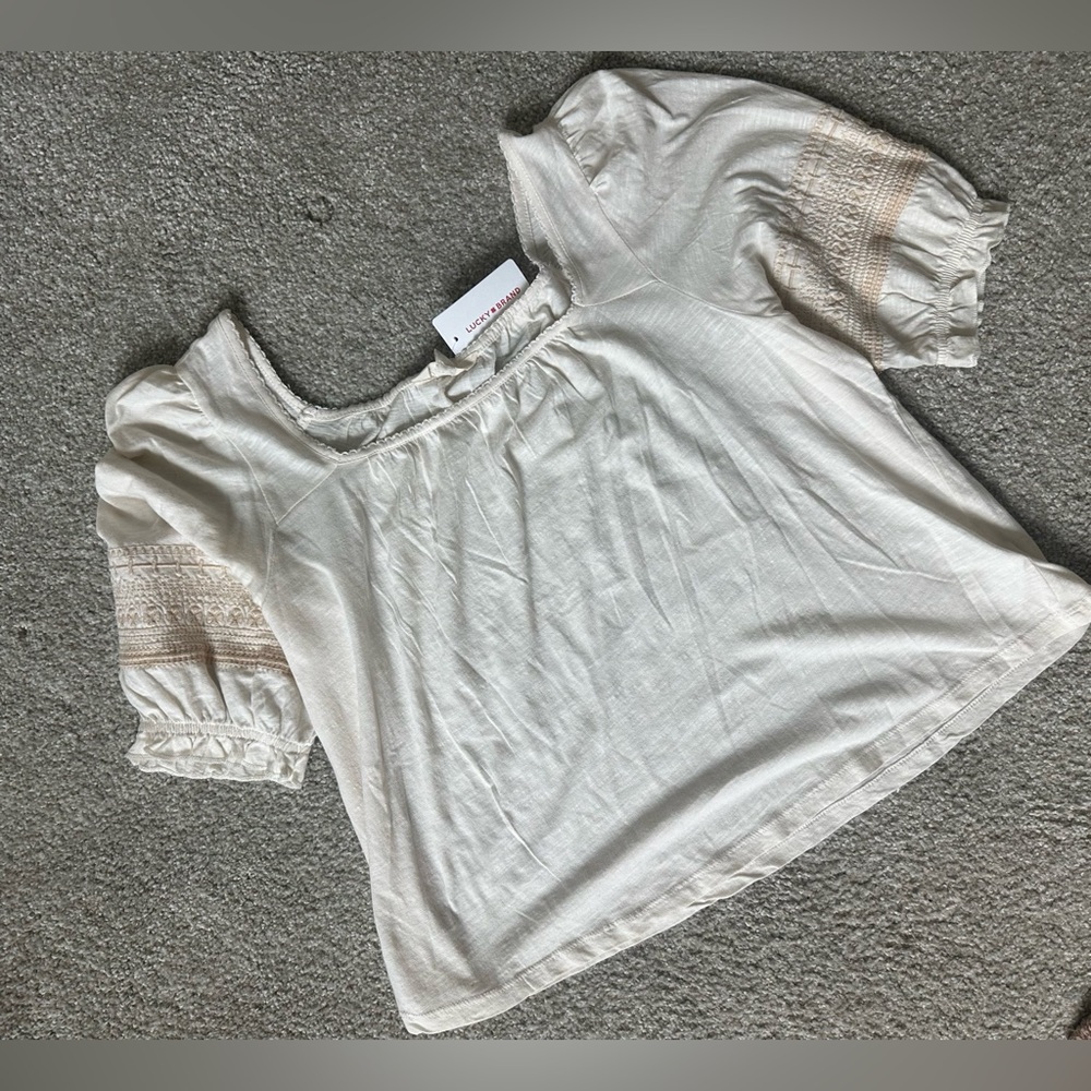 NWT- Cream blouse from Lucky Brand featuring embroidered sleeves.